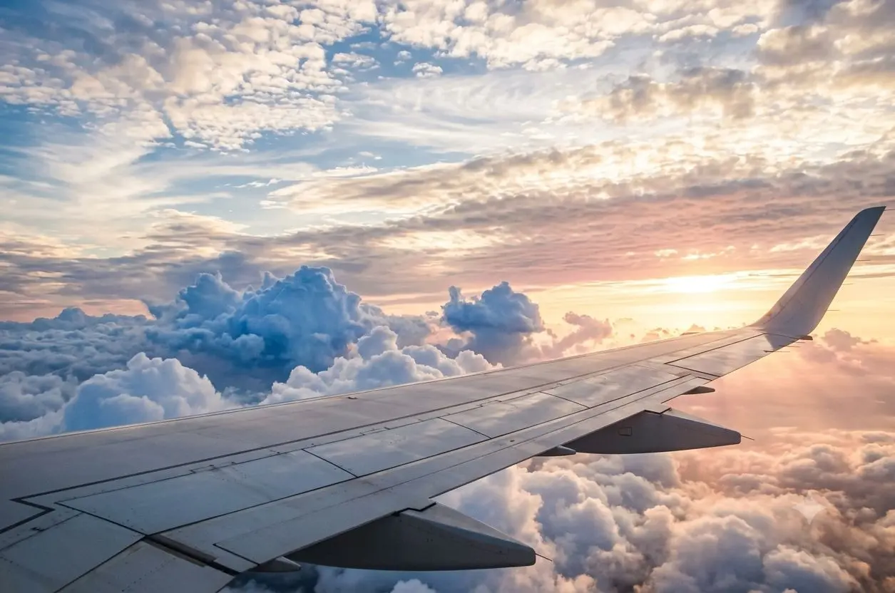 Commercial passenger airplane flying above clouds - Huute Travel and Cargo flight booking services for popular routes from Nairobi to Dubai, London, and Jeddah